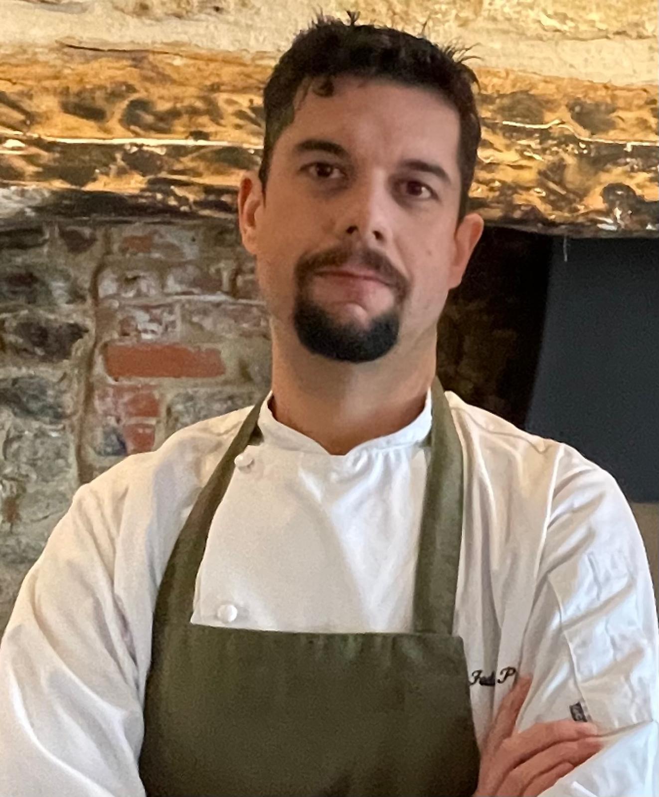 Fred Puglisi in chef whites and an apron